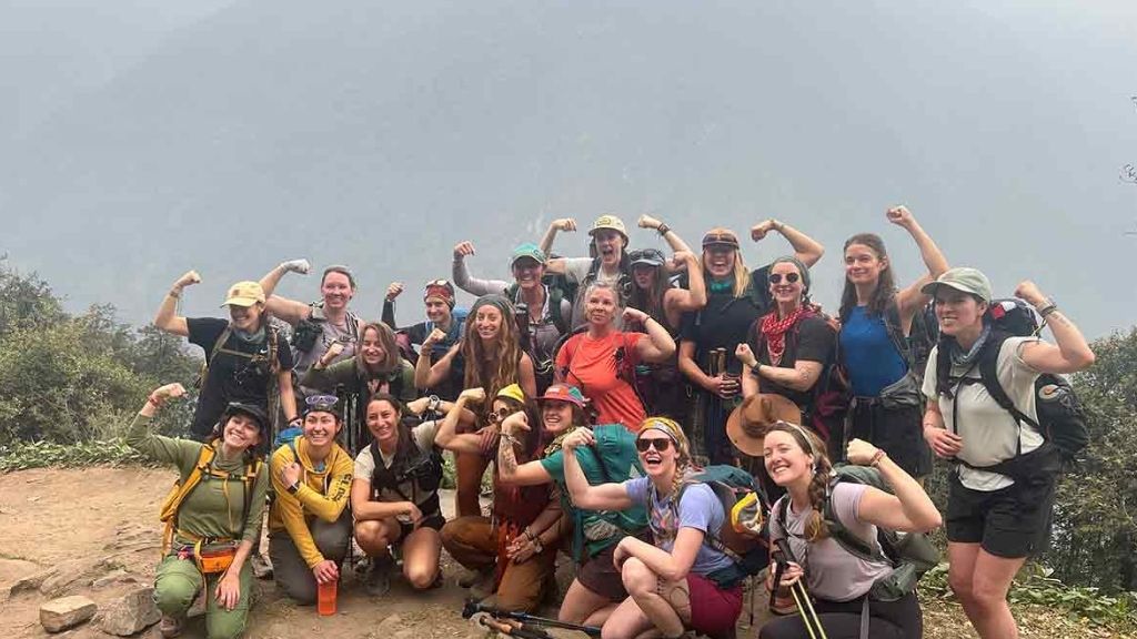 Trekkers flexing muscles on ridge