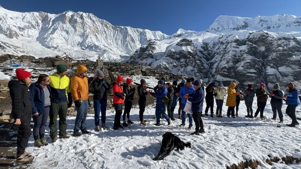 group of trekkers standing at the iconic Annapurna Base Camp